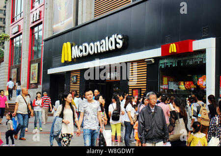 --FILE--piétons passent devant un restaurant de fast-food McDonald's à Chongqing, Chine, le 20 septembre 2015. McDonald's Shanghai chaînes seront la firs Banque D'Images