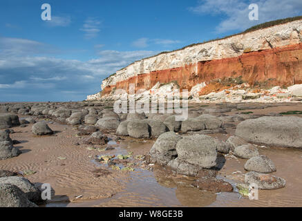 Falaises, à rayures Hunstanton avec rochers arrondis sur la plage. Banque D'Images