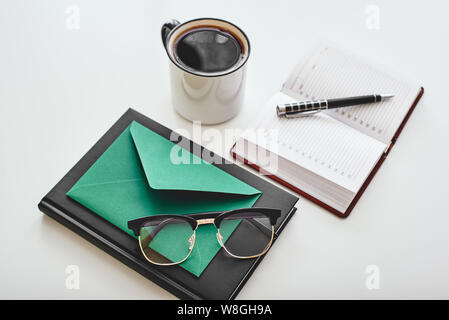 Tasse de café isolé, enveloppe, stylo, ordinateurs portables et verres couché sur un fond blanc. Plan horizontal Banque D'Images