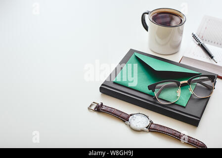 Tasse de café isolé, enveloppe, stylo, naturelle, regarder et verres couché sur un fond blanc. Plan horizontal Banque D'Images