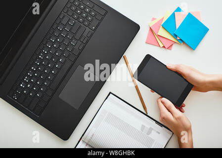 Rappel Les papiers d'affaires, ordinateur portable, portable et d'un crayon posé sur la table sur fond blanc. Plan horizontal. Des idées d'entreprise concept Banque D'Images