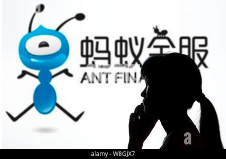 --FILE--un piéton parle sur son téléphone mobile devant une publicité pour Ant Financial Services, une filiale du géant de l'e-commerce chinois Aliba Banque D'Images