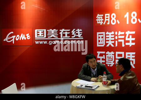 --FILE--Un employé parle chinois avec un visiteur sur le stand d'gome.com.cn of home appliance retailer Gome au cours de l'Automechanika 2014 Shanghai (SUIS Banque D'Images