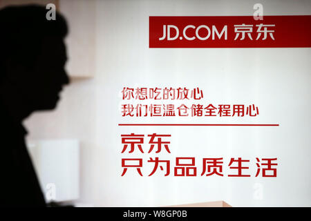 --FILE--un piéton passe devant une publicité pour la vente en ligne en chinois JD.com à Shanghai, Chine, le 2 décembre 2015. La vente directe en ligne Banque D'Images