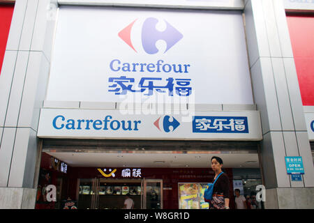 --FILE--un piéton passe devant un supermarché de Carrefour à Chongqing, Chine, 11 octobre 2015. Distributeur français Carrefour a réalisé un chiffre d'environ 21 Banque D'Images