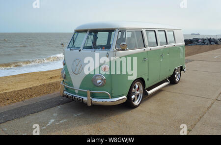 Vert et blanc classique VW Camper Van stationné sur une promenade de bord de mer. Banque D'Images