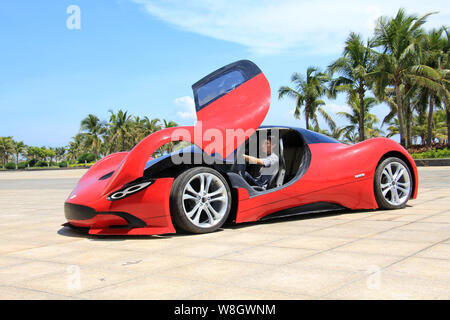 Les jeunes Chinois Chen Yinxi pose à l'intérieur de sa voiture de sport électrique maison à Hainan International Convention & Exhibition Centre de Haikou City, sout Banque D'Images