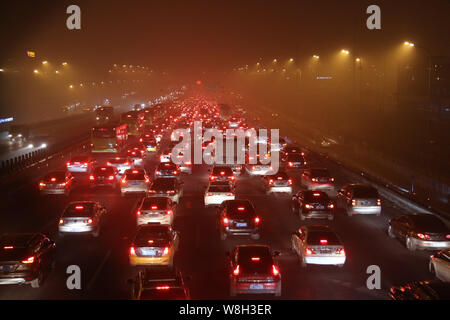 Masses de véhicules se déplacent lentement au cours d'un embouteillage sur une route dans le smog lourde à Beijing, Chine, 30 novembre 2015. Pékin a de nouveau envahi par de lourdes Banque D'Images
