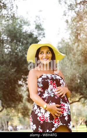 Enceinte femme péruvienne dans une forêt, belle jeune fille péruvienne en attente d'un enfant, une femme coquine aux cheveux noirs en robe et chapeau sur la nature Banque D'Images