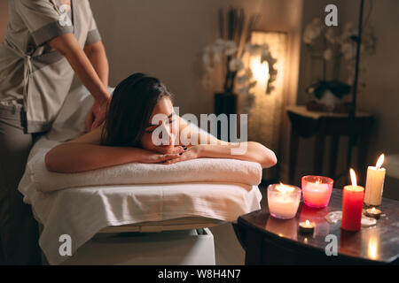 Spa, massage. Jeune fille belle brune se faisant masser. Banque D'Images