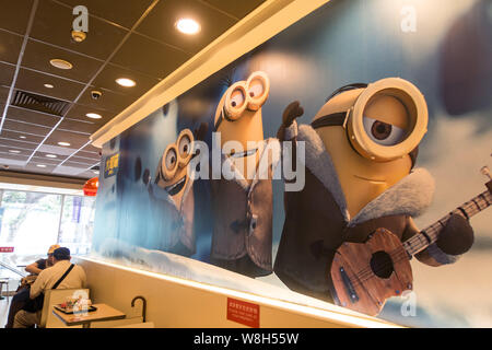 Les clients mangent au McDonald's sur le thème des sbires restaurant fast-food à Shanghai, Chine, le 3 juillet 2015. Les séides de Universal Pictures et Illuminati Banque D'Images