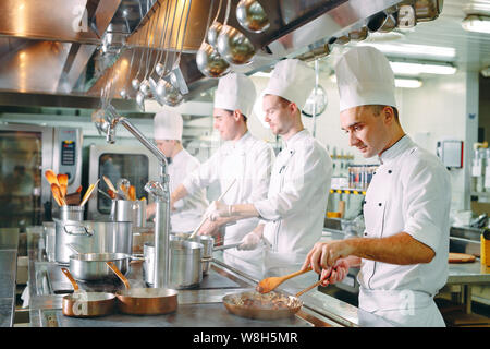 Cuisine moderne. Les cuisiniers préparent les repas sur la cuisinière dans la cuisine du restaurant ou hôtel. L'incendie dans la cuisine. Banque D'Images