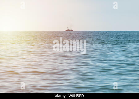 Bateau de pêche en mer. Chalutier bateau solitaire va au port pour vendre la prise de poisson. Claire calme ensoleillé. Bel Horizon du paysage marin. Banque D'Images
