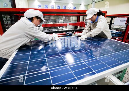 --FILE--femmes travailleurs chinois vérifier la production de cellules photovoltaïques pour panneaux solaires à l'usine de Shanghai nouvelle énergie Shenzhou Development Co., L Banque D'Images