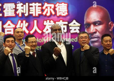 Champion du monde de boxe américain Evander Holyfield, troisième à droite, pose avec les dirigeants lors d'une conférence de presse et cérémonie de signature de devenir un VIP moi senior Banque D'Images