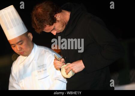 Joueur de tennis britannique Andy Murray, à droite, signe son autographe sur un bateau à vapeur de bambou comme il apprend à partir de boulettes de faire un chef à un événement promotionnel pour Banque D'Images