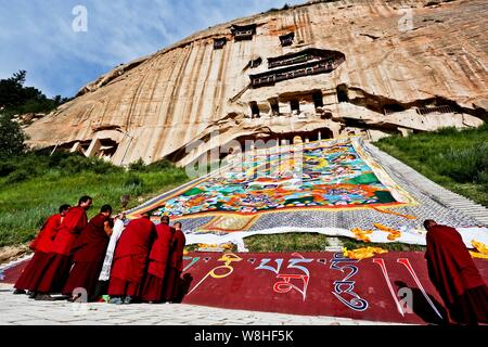 Un immense culte Lamas de Thangka de l'ensoleillement au cours de Bouddha Bouddha Festival (Shaifo Jie) à Mati Temple dans Sunan Yugur comté autonome, dans les C Banque D'Images