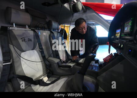 Un visiteur regarde à l'intérieur de la Chine electric light sport aircraft RX1E Ruixiang sur l'affichage pendant la cérémonie de signature du contrat de vente Banque D'Images