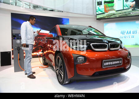 --FILE--un visiteur regarde une voiture électrique BMW i3 sur l'affichage à l'2014 China International Industry Fair à Shanghai, Chine, 4 novembre 2014. Dans un Banque D'Images