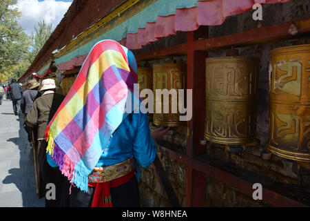 --FILE--une femme habillé en costume tibétain tourne roues de prière dans le Palais du Potala à Lhassa, le sud-ouest de la Chine, région autonome du Tibet, 10 octobre 20 Banque D'Images