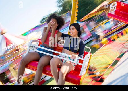 Deux jeunes femmes sur le parc d'amusement ride au juste. Banque D'Images