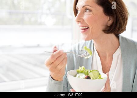 Young woman eating salad. Banque D'Images