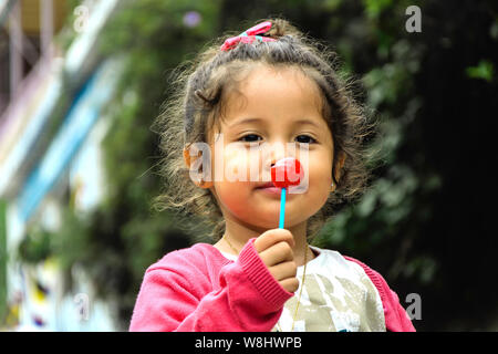 Portrait of cute girl with lollipop in the park Banque D'Images