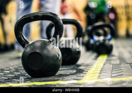 Différentes tailles de kettlebells haltères allongé sur plancher du gymnase. Matériel souvent utilisé pour la formation au crossfit fitness club Banque D'Images