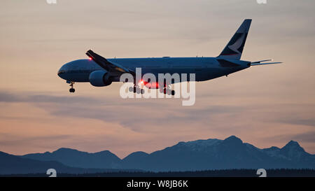 Cathay Pacific Airways avion Boeing 777-300ER airborne en courte finale pour l'atterrissage au coucher du soleil au crépuscule crépuscule avion de ligne Avion Swire Group Banque D'Images