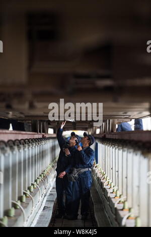 Techniciens chinois examiner un CRH (China railway High-speed), le train pour le prochain Nouvel An chinois ou la fête du printemps à la maintena Banque D'Images