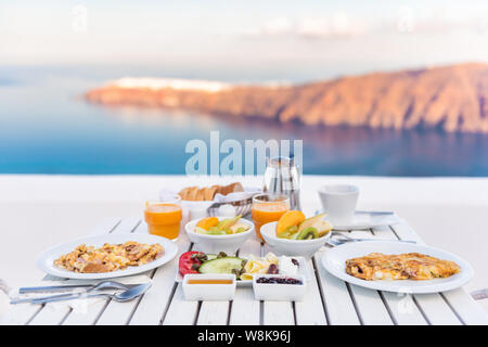 Table de petit-déjeuner romantique en la mer. Petit-déjeuner de luxe parfait table pour deux à l'extérieur. Incroyable sur la caldeira de Santorin, Grèce, Europe. Banque D'Images