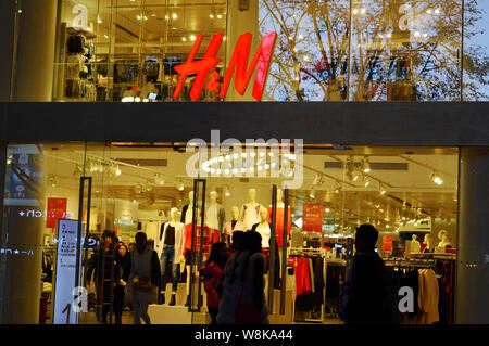 --FILE--piétons devant une boutique de mode de H&M à Chongqing, Chine, 14 février 2016. H&M a annoncé que son bénéfice net pour le premier Banque D'Images