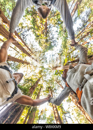 Les amis de les amoureux de la nature, respectueux de l'écolos. Groupe de personnes tenant la main de prier en forêt formant un cercle dans la prière pour l'espoir d'une meilleure terre. Concept de l'environnement. Banque D'Images