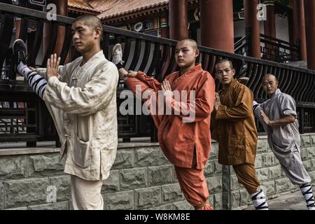 Moines chinois se dégourdir les jambes qu'ils pratiquent et kungfu arts martiaux à l'ouest de Temple de Shaolin dans Chongtou village, ville de Zhongshan, Chongqing, C Banque D'Images