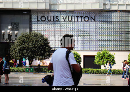 --FILE--piétons devant une boutique de mode de Louis Vuitton (LV) à Chongqing, Chine, 11 octobre 2015. LVMH, le plus grand groupe de luxe, Banque D'Images