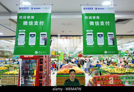 --FILE--un client entre dans le cadre de publicités pour le paiement de l'application messagerie WeChat Weixin, ou de Tencent WeChat, dans un supermarché dans la ville de Hangzhou, EAS Banque D'Images