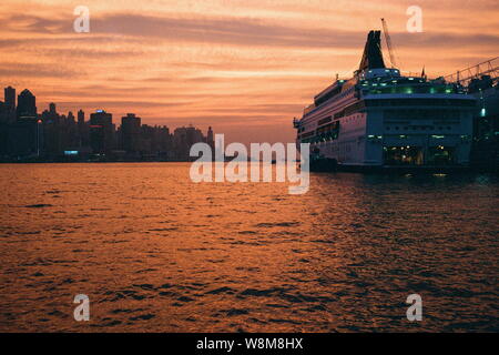 Un bateau de croisière est vu amarré au port de Victoria au coucher du soleil à Tsim Sha Tsui, Hong Kong, Chine, décembre 2015. Avec l'impact de l'international e Banque D'Images