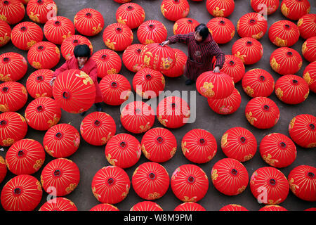 Les travailleurs chinois nouvellement arrivée faite des lampions rouges à une lanterne dans l'usine Huzhen Beishan village, ville, comté de Qingdao, Hangzhou City, Zhejiang en Chine de l'Est Banque D'Images