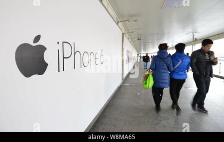 --FILE--piétons passent devant une publicité pour l'iPhone 6 d'Apple à une station de métro à Shanghai, Chine, 13 février 2015. Les expéditions de la Chine de SMA Banque D'Images