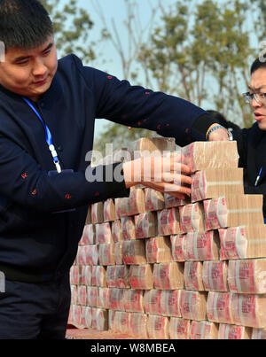 Employés chinois préparer des piles de 100 RMB (Yuan-Renminbi), les billets pour les salaires des travailleurs migrants sur le site de construction d'un projet immobilier Banque D'Images