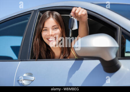 Location de voiture ou une commande de nouveaux drivers license concept. Jeune adolescent femme conducteur titulaire car key driving sa nouvelle voiture. Belle femme asiatique multiraciale smiling montrant de nouvelles clés de voiture. Banque D'Images