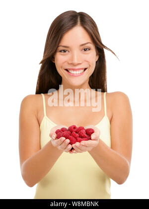 Femme tenant de framboises fraîches en mains libre isolé sur fond blanc. Portrait of Asian woman showing poignée de framboises rouges en femme mains. De framboise berry concept. Banque D'Images