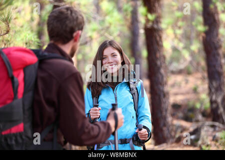 Heureux les jeunes randonneurs friends having fun parler ensemble pendant les feux de randonnée dans les montagnes. Les gens de la randonnée avec des bâtons de marche et des sacs à dos dans la nature, vie en plein air. Asian Woman, man. Banque D'Images