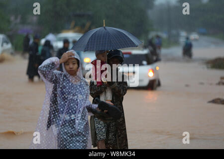 Yangon, Myanmar. 10 août, 2019. Les gens à pied sur une route inondée lors de pluies de mousson dans Paung Township, l'État Môn, Myanmar, 10 août 2019. Nombre de décès causés par la mousson vendredi était passé à 29 glissement jusqu'à présent dans mon état, selon les derniers chiffres publiés par le Département des services d'incendie du Myanmar le samedi. Causées par de fortes pluies de mousson, Paung, Mawlamyine, Mudon, Thanbyuzayat, Kyaikmaraw, Ye townships ont été inondés. Credit : U Aung/Xinhua/Alamy Live News Banque D'Images