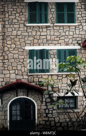 L'architecture française incroyable de l'ancienne maison en pierre avec fenêtre en bois vert et porte, mur de pierre extérieur de la villa lien pour l'histoire, Da Lat, Viet Nam Banque D'Images