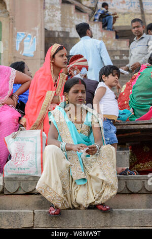 Les femmes indiennes vêtues de saris s'asseoir sur les marches d'un ghat à sur le Gange à Varanasi, Uttar Pradesh, Inde, Asie du Sud. Banque D'Images