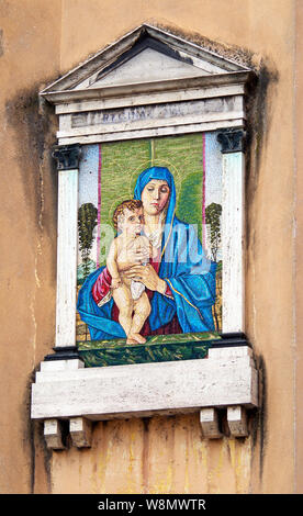 Une reproduction en mosaïque d'une peinture de Giovanni Bellini de la madone berçant l'enfant Christ, monté haut sur un mur de la rue de Crémone (Italie). Banque D'Images