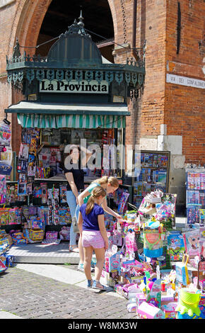 Cremona, Italie. D'un kiosque situé dans la Piazza del située dans le coeur de la ville, avec des magazines et des jouets de répandre sur le trottoir. Banque D'Images