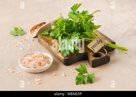 Sel de l'himalaya rose et un bouquet de persil frais avec une balise. Les herbes et épices pour la cuisine. Banque D'Images
