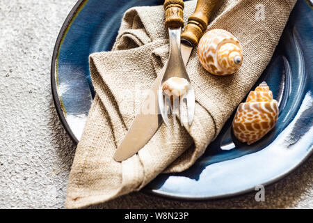 Ensemble de coutellerie marine avec des coquillages et des étoiles de mer sur fond de béton gris with copy space Banque D'Images